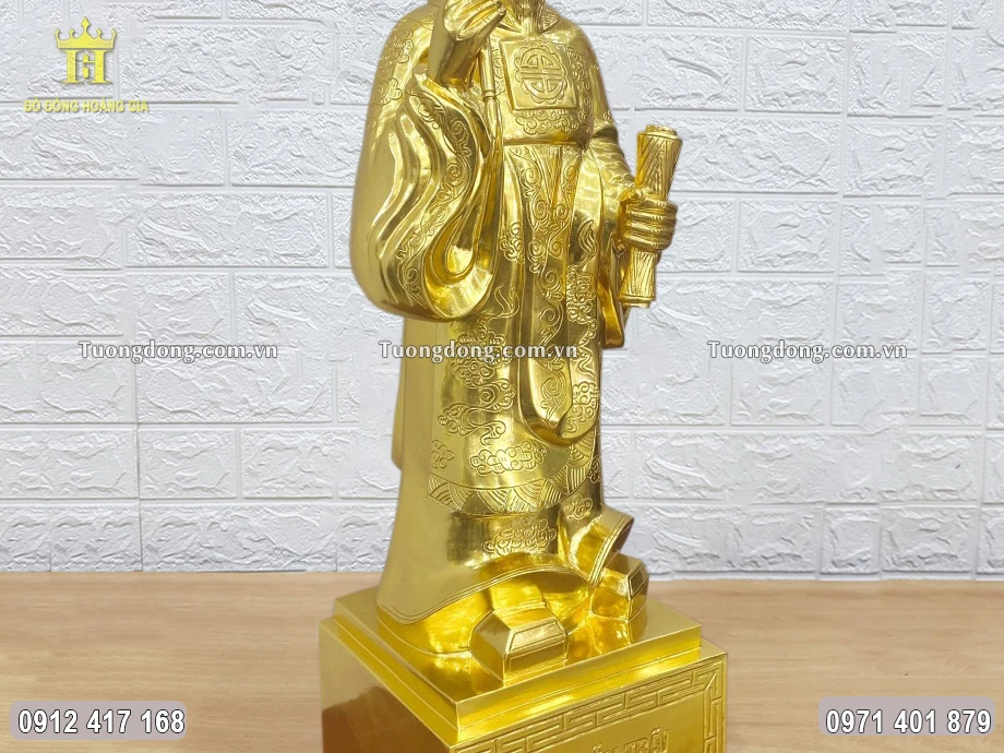 Tay phải ông cầm bút lông, tay trái cầm cuốn thư